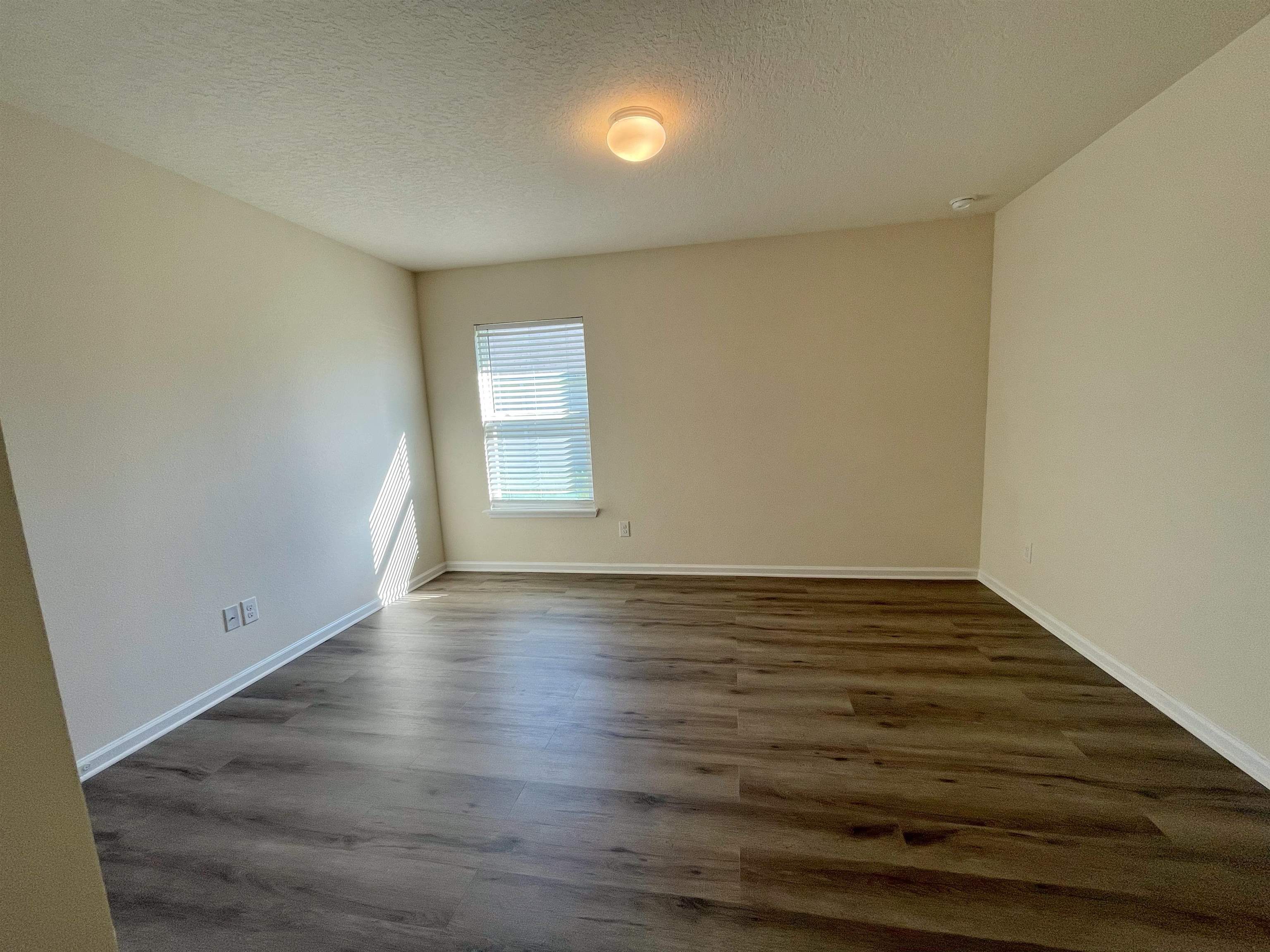 578 Deer Crossing Road St. Augustine, FL 32086 - Photo 18 of 28 a view of an empty room with wooden floor and a window