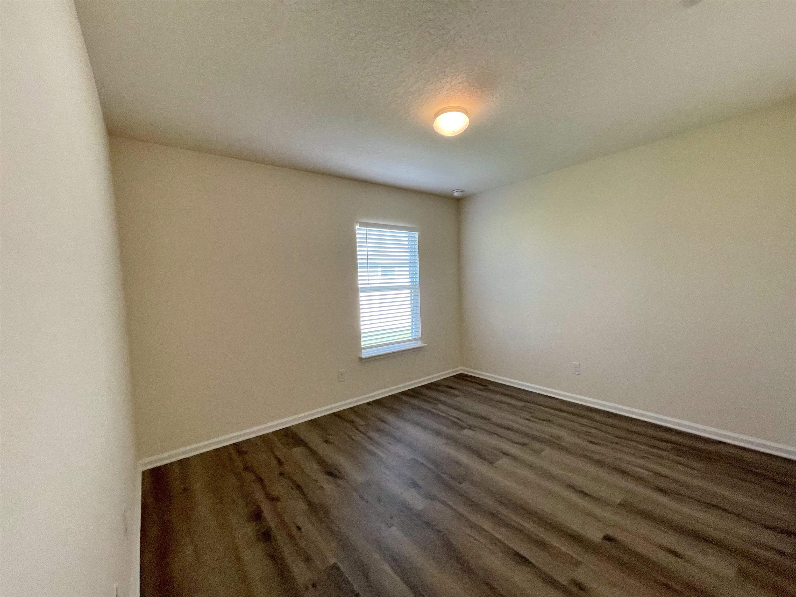 578 Deer Crossing Road St. Augustine, FL 32086 - Photo 20 of 28 a view of an empty room with wooden floor and a window