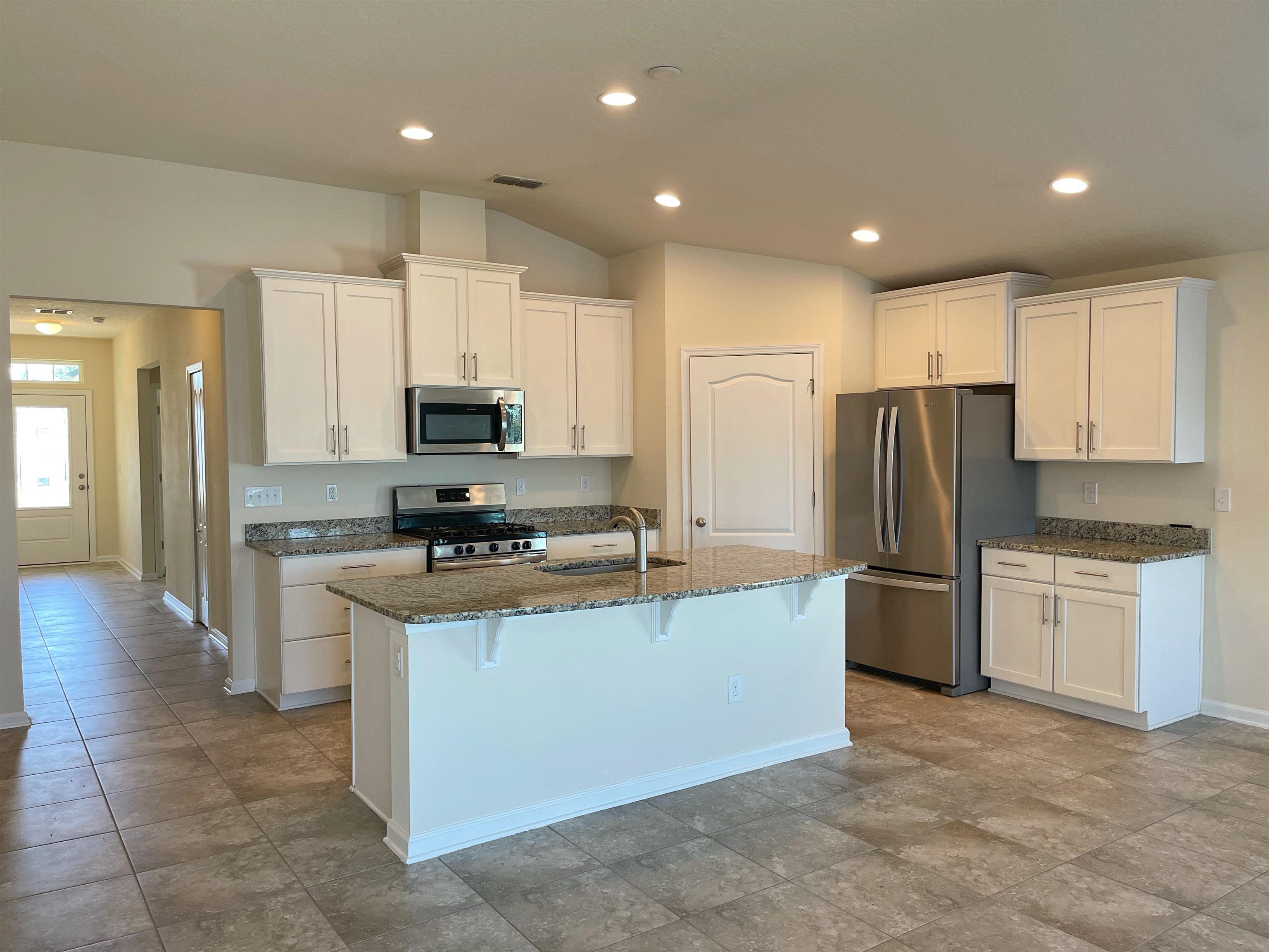 578 Deer Crossing Road St. Augustine, FL 32086 - Photo 4 of 28 a kitchen with stainless steel appliances granite countertop a refrigerator stove top oven and sink