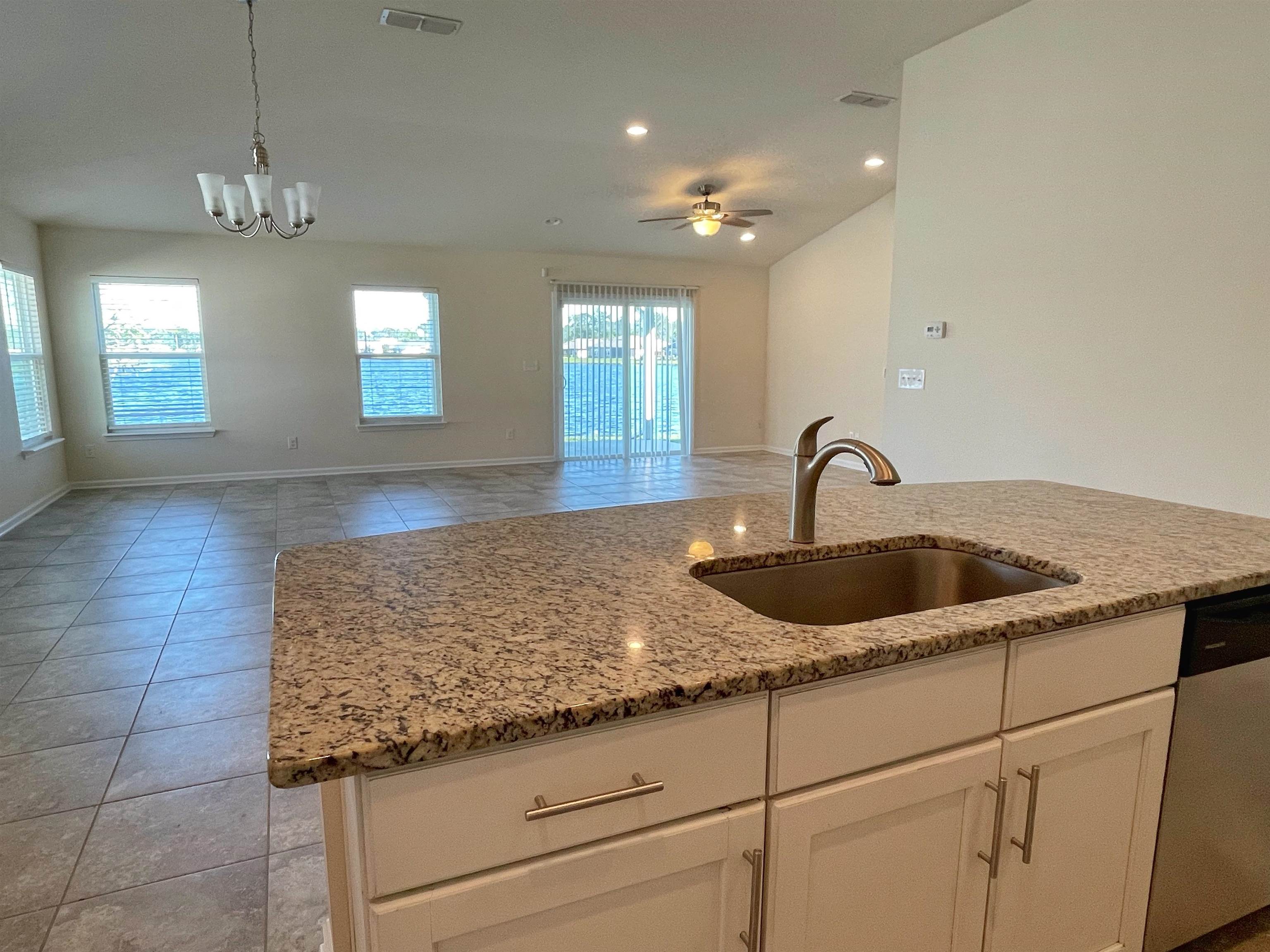 578 Deer Crossing Road St. Augustine, FL 32086 - Photo 7 of 28 a kitchen with granite countertop a sink and white cabinets
