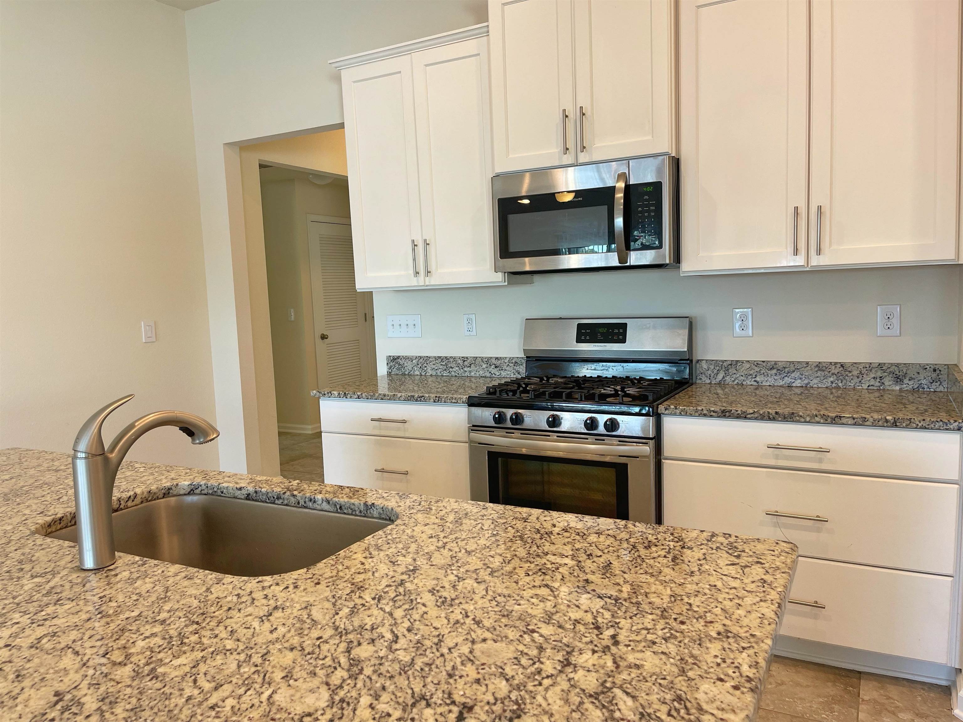 578 Deer Crossing Road St. Augustine, FL 32086 - Photo 8 of 28 a kitchen with stainless steel appliances granite countertop a sink a stove a microwave and cabinets