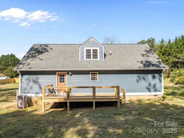 a view of a house with pool lawn chairs and a yard
