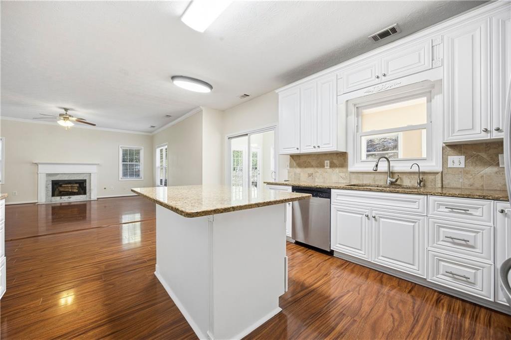 3393 Morning Top Place Suwanee, GA 30024 - Photo 11 of 34 a kitchen with granite countertop a sink cabinets and wooden floor