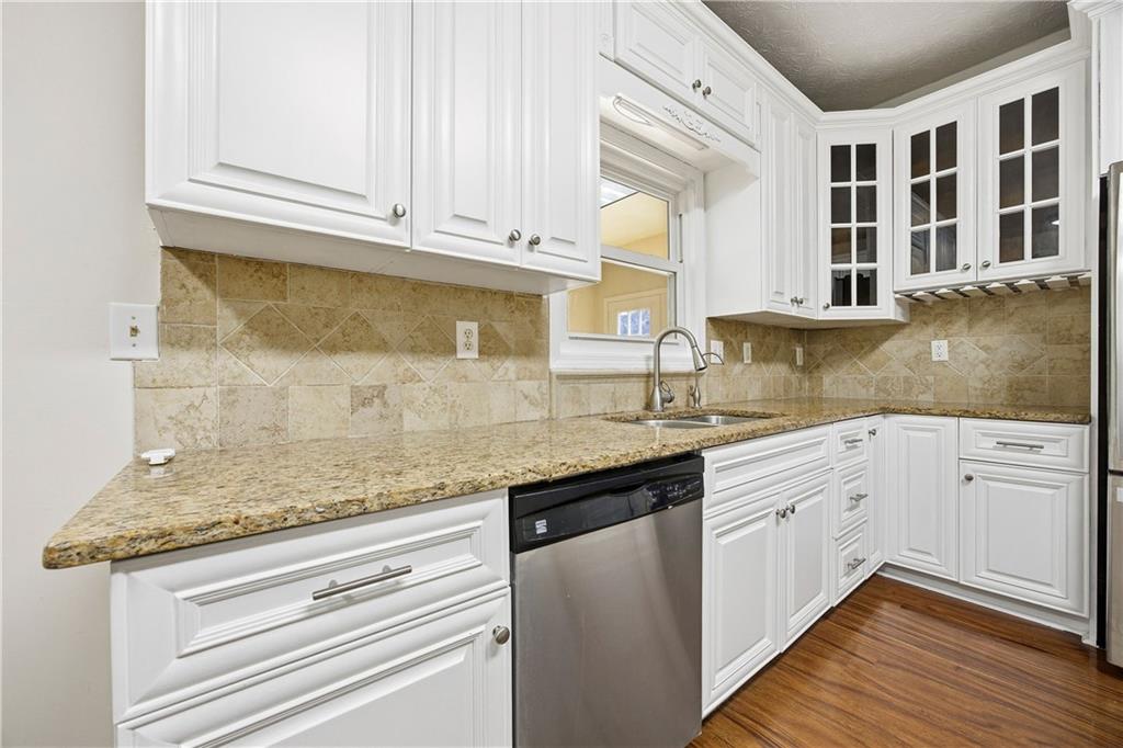 3393 Morning Top Place Suwanee, GA 30024 - Photo 12 of 34 a kitchen with stainless steel appliances granite countertop a sink and cabinets with wooden floor