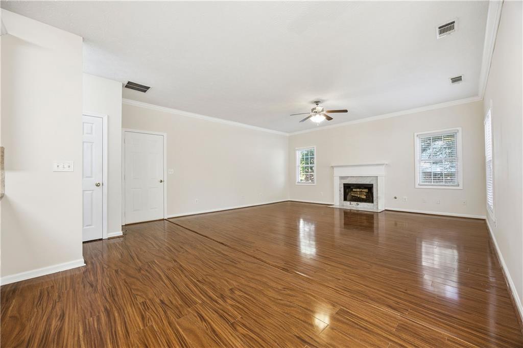 3393 Morning Top Place Suwanee, GA 30024 - Photo 16 of 34 a view of empty room with wooden floor and fireplace