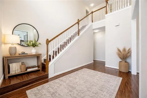 a view of staircase with wooden floor and a rug