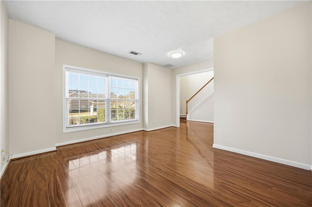 3393 Morning Top Place Suwanee, GA 30024 - Photo 7 of 34 a view of an empty room with wooden floor and a window