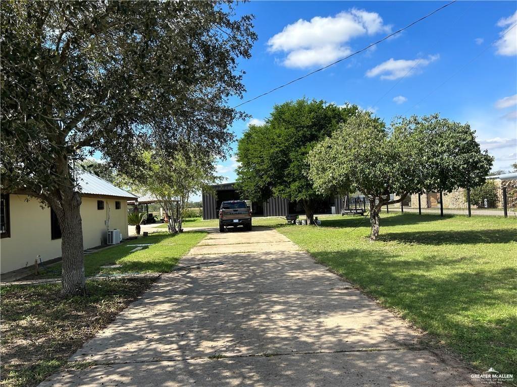 9433 North Minnesota Road Mission, TX 78574 - Photo 2 of 18 a view of a house with a big yard and large trees