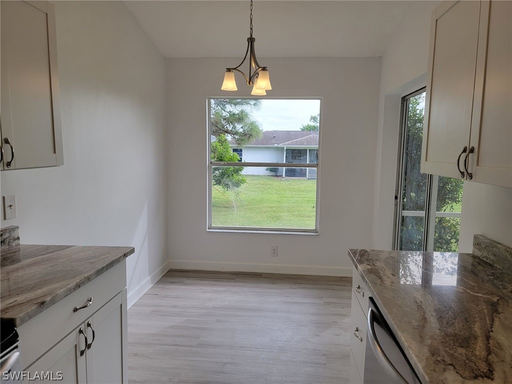 17565 Braddock Road Fort Myers, FL 33967 - Photo 11 of 19 a kitchen with stainless steel appliances granite countertop a sink a stove and a wooden floor
