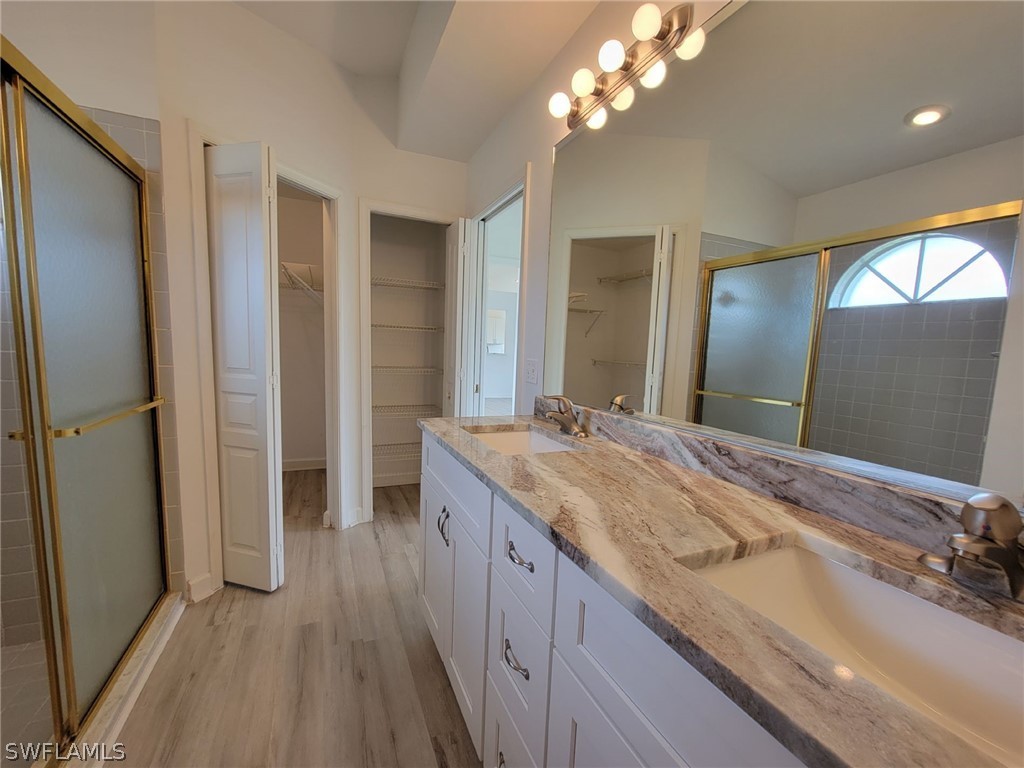 17565 Braddock Road Fort Myers, FL 33967 - Photo 18 of 19 a spacious bathroom with a granite countertop sink a mirror and a shower