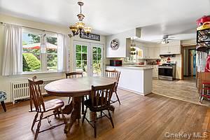 178 Barnes Road, Unit MAIN HOUSE Brookhaven, NY 11955 - Photo 15 of 17 a dining room with furniture a chandelier and wooden floor