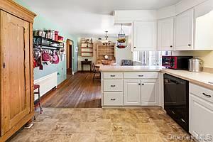 178 Barnes Road, Unit MAIN HOUSE Brookhaven, NY 11955 - Photo 4 of 5 Kitchen with white cabinets, light countertops, a peninsula, and black dishwasher