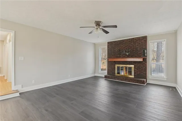 a view of wooden floor a fire place and windows in a room