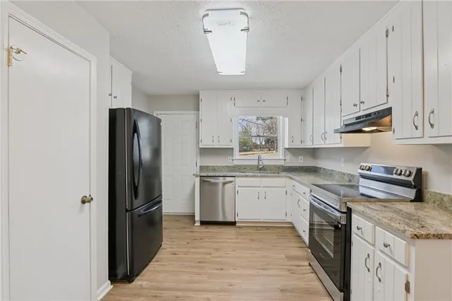 a kitchen with stainless steel appliances granite countertop a refrigerator sink and cabinets