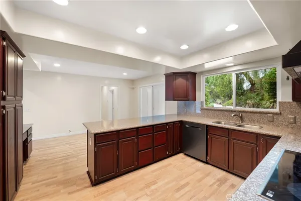 a kitchen with stainless steel appliances granite countertop a sink and a white cabinets