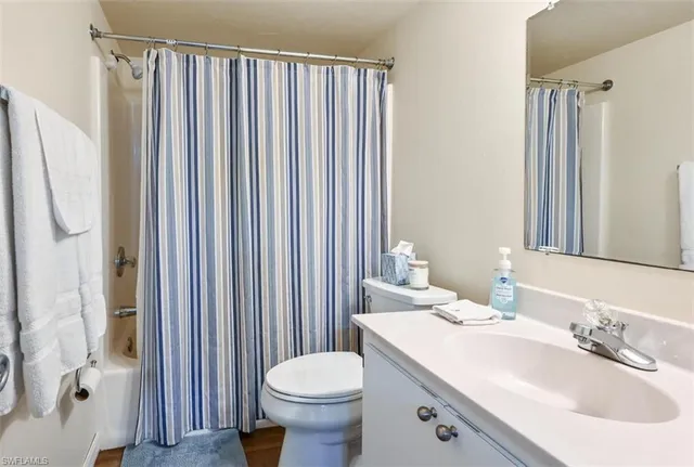 a bathroom with a sink a toilet and shower curtain