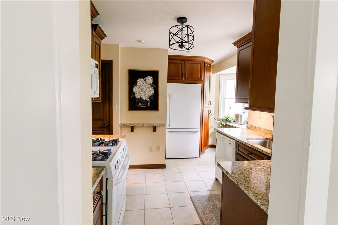 5275 Spencer Road Cleveland, OH 44124 - Photo 13 of 38 Kitchen featuring light stone countertops, decorative light fixtures, light tile patterned floors, and white appliances