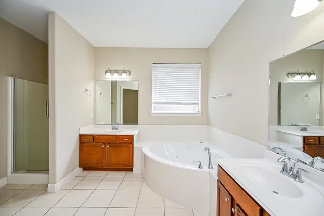 a spacious bathroom with a bathtub sink and mirror