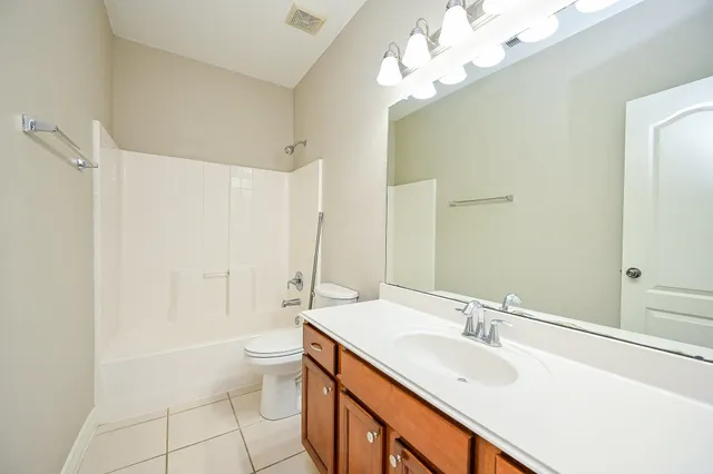 a bathroom with a double vanity sink mirror and toilet
