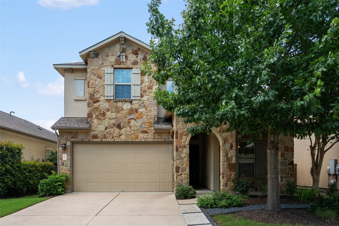 Undisclosed Address Austin, TX 78726 - Photo 1 of 1 View of front of home with stone siding, driveway, and an attached garage