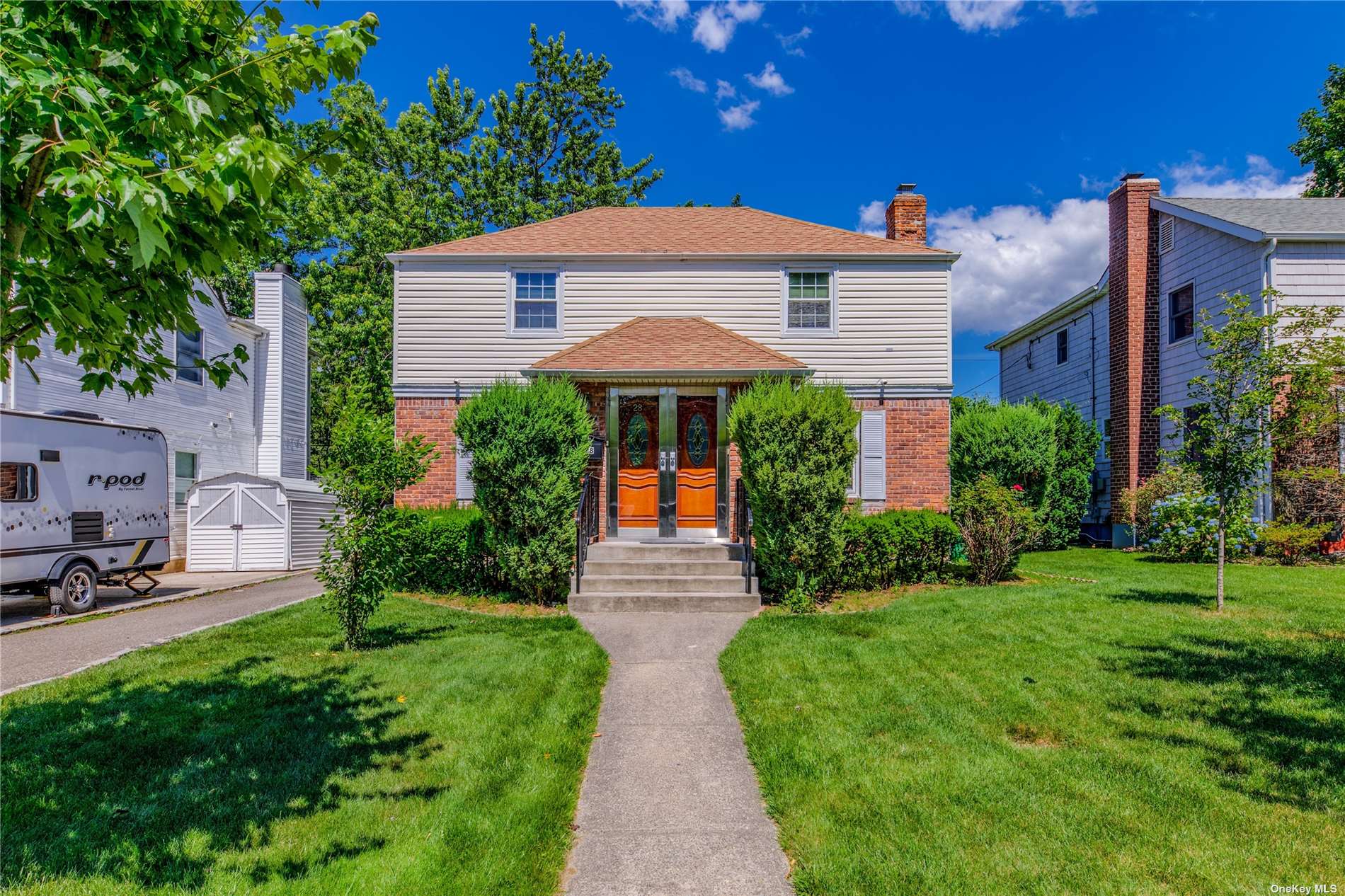 28 Wilwade Road Great Neck, NY 11020 - Photo 1 of 1 a front view of a house with garden