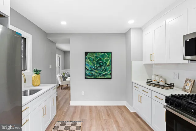 a kitchen with stainless steel appliances a refrigerator a sink a stove a counter space and cabinets