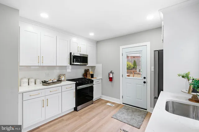 a kitchen with stainless steel appliances granite countertop a refrigerator sink and stove
