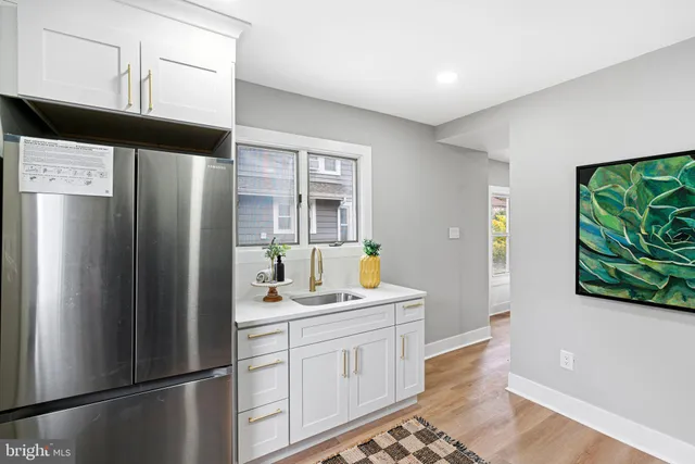 a kitchen with stainless steel appliances a refrigerator sink and wooden floor