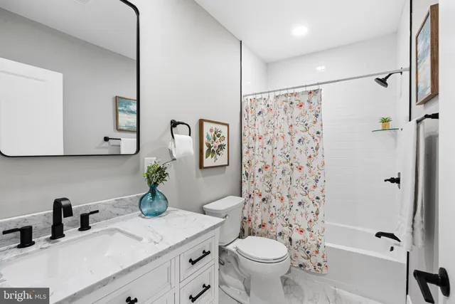 a bathroom with a sink toilet a mirror and shower