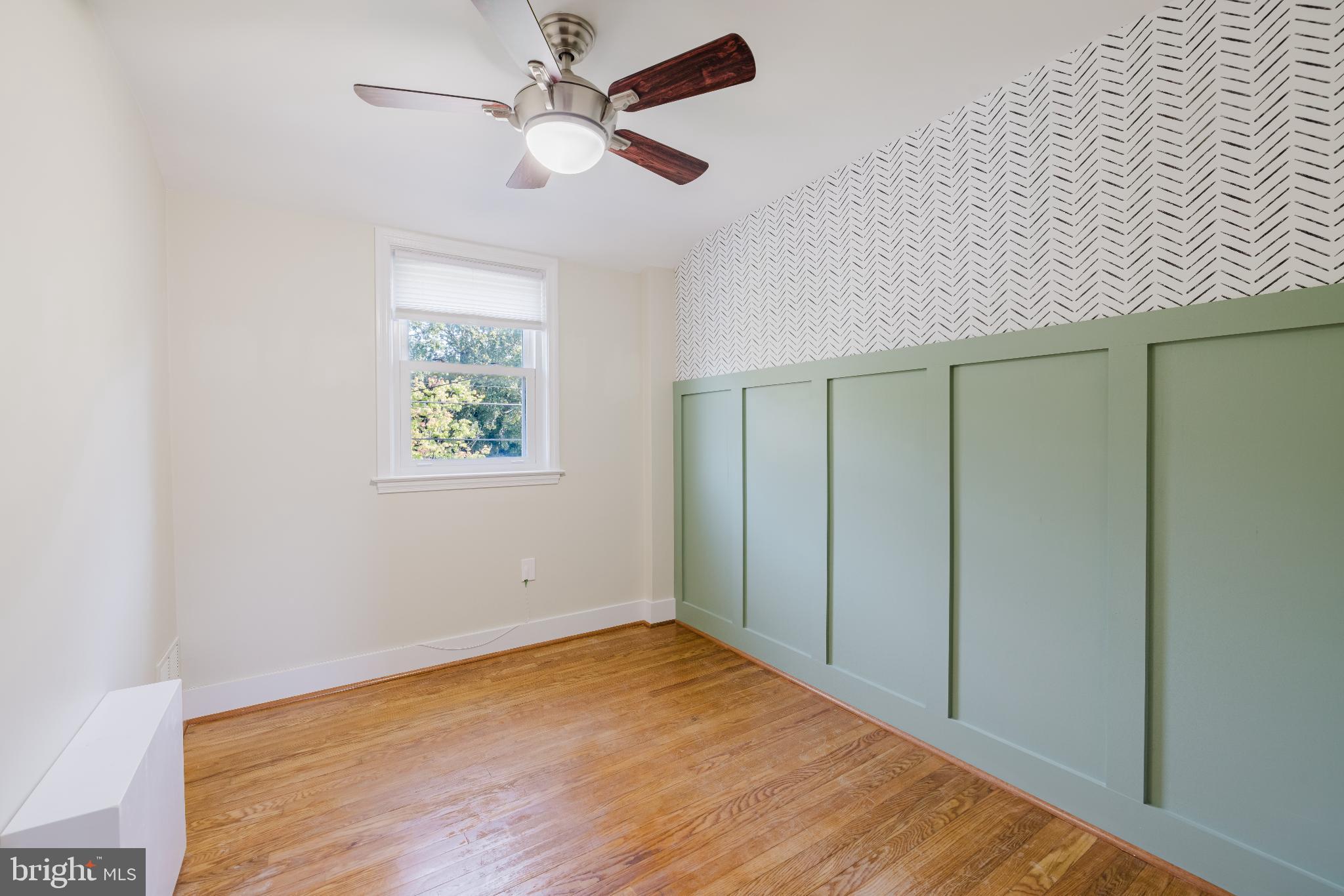 1636 Thetford Road Baltimore, MD 21286 - Photo 12 of 23 an empty room with wooden floor ceiling fan and windows