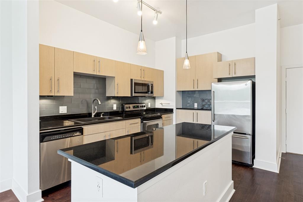 4414 Cedar Springs Road, Unit 320 Dallas, TX 75219 - Photo 6 of 17 a kitchen with stainless steel appliances granite countertop a sink a stove a refrigerator and white cabinets