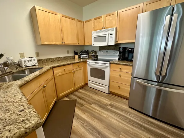 a kitchen with stainless steel appliances granite countertop a refrigerator sink and stove
