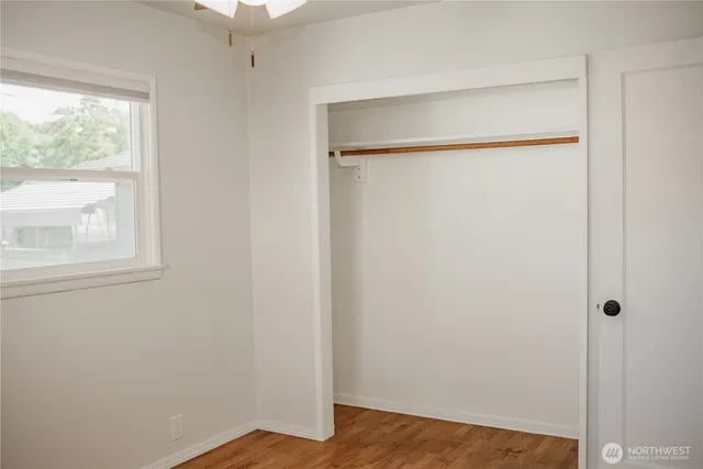 a view of empty room with wooden floor and floor to ceiling window