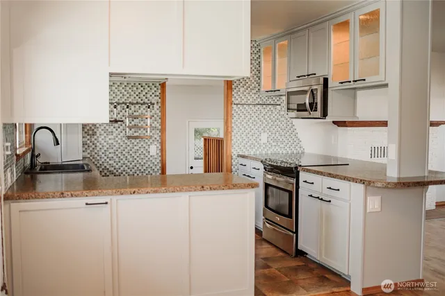 a kitchen with stainless steel appliances granite countertop a sink and a stove