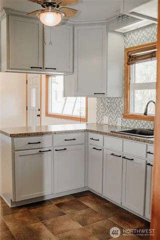 a kitchen with granite countertop a sink cabinets and window