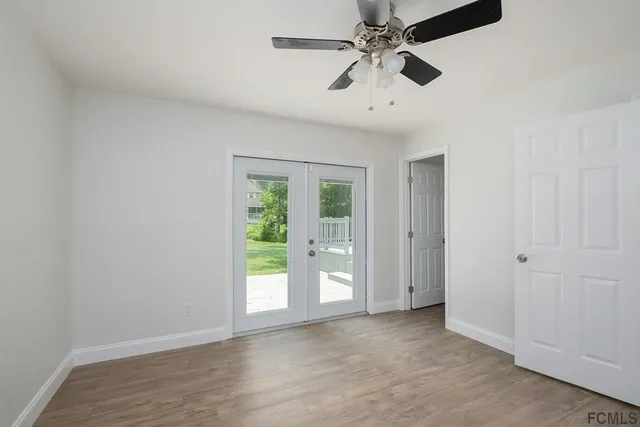 an empty room with fan and windows
