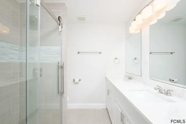 a bathroom with a tub sink vanity granite and shower