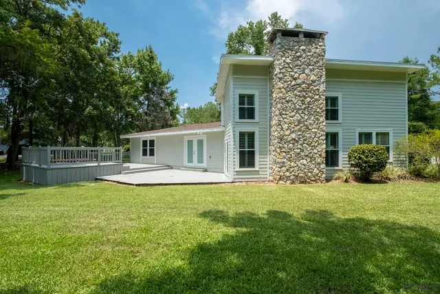 a view of house with backyard and swimming pool