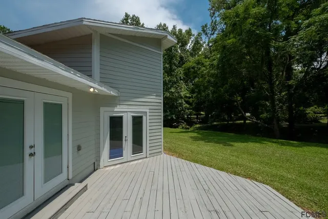 a view of backyard with deck and wooden floor