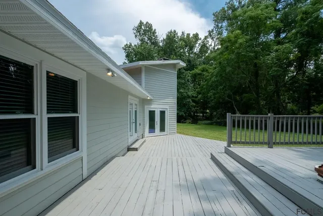 a view of a wooden deck and a backyard