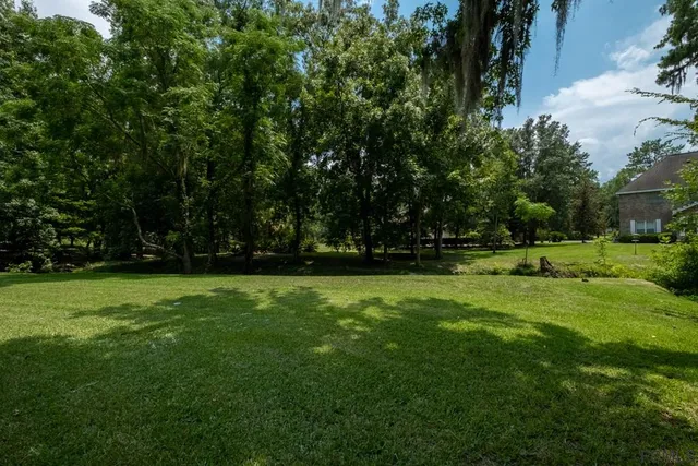 an aerial view of residential house with outdoor space and trees all around