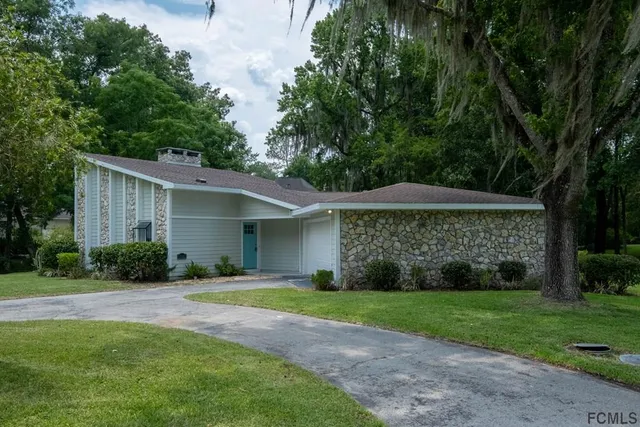 a front view of house with yard and trees