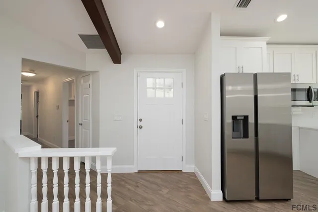 a metallic refrigerator freezer sitting inside of a kitchen