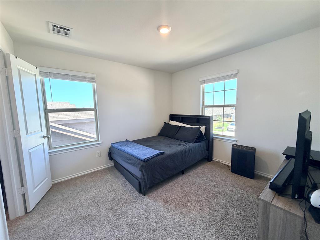 816 Country Road Royse City, TX 75189 - Photo 13 of 24 Carpeted room featuring two windows with blinds, a white paneled door, and a flush-mount ceiling light