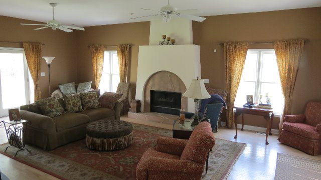 1143 Klopfer Road Macon, GA 31210 - Photo 5 of 19 a living room with furniture a fireplace and a chandelier