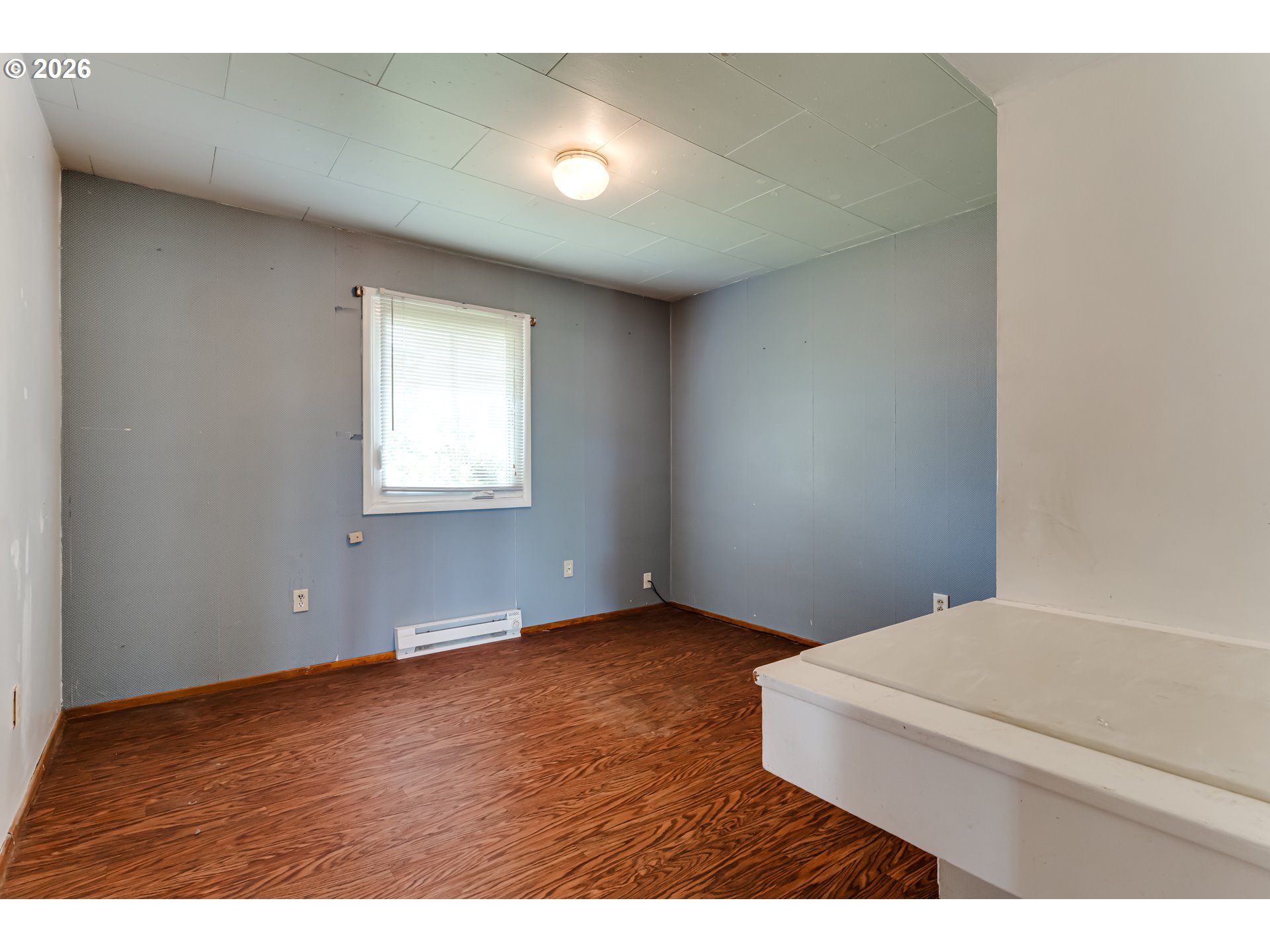 4076 North Street Springfield, OR 97478 - Photo 13 of 21 a view of an empty room with wooden floor and a window