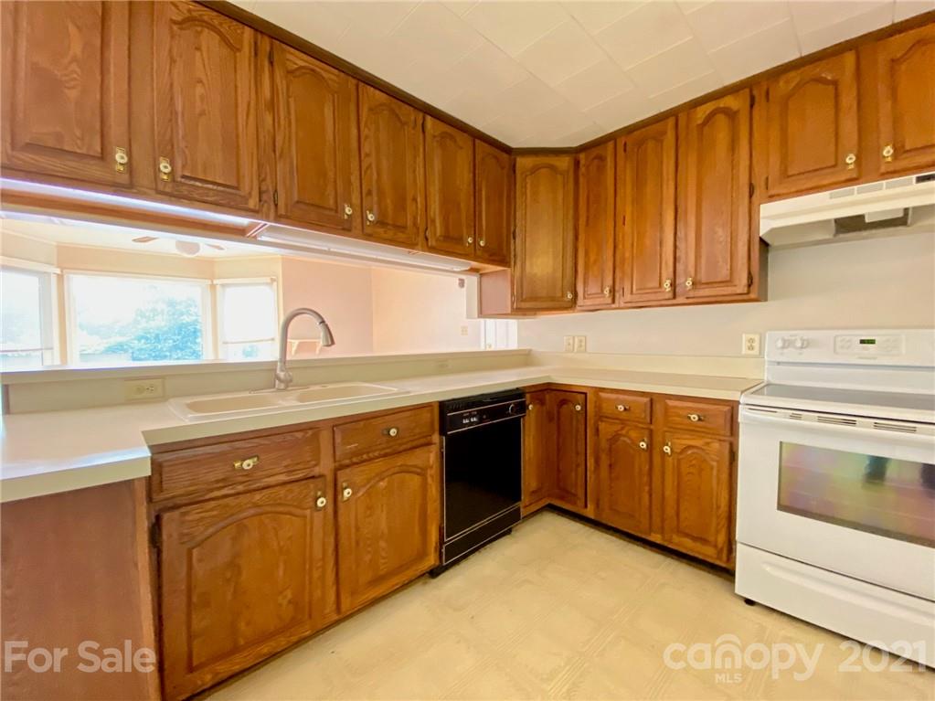 8930 Cool Springs Road Woodleaf, NC 27054 - Photo 23 of 42 a kitchen with stainless steel appliances granite countertop a sink dishwasher stove and cabinets with wooden floor