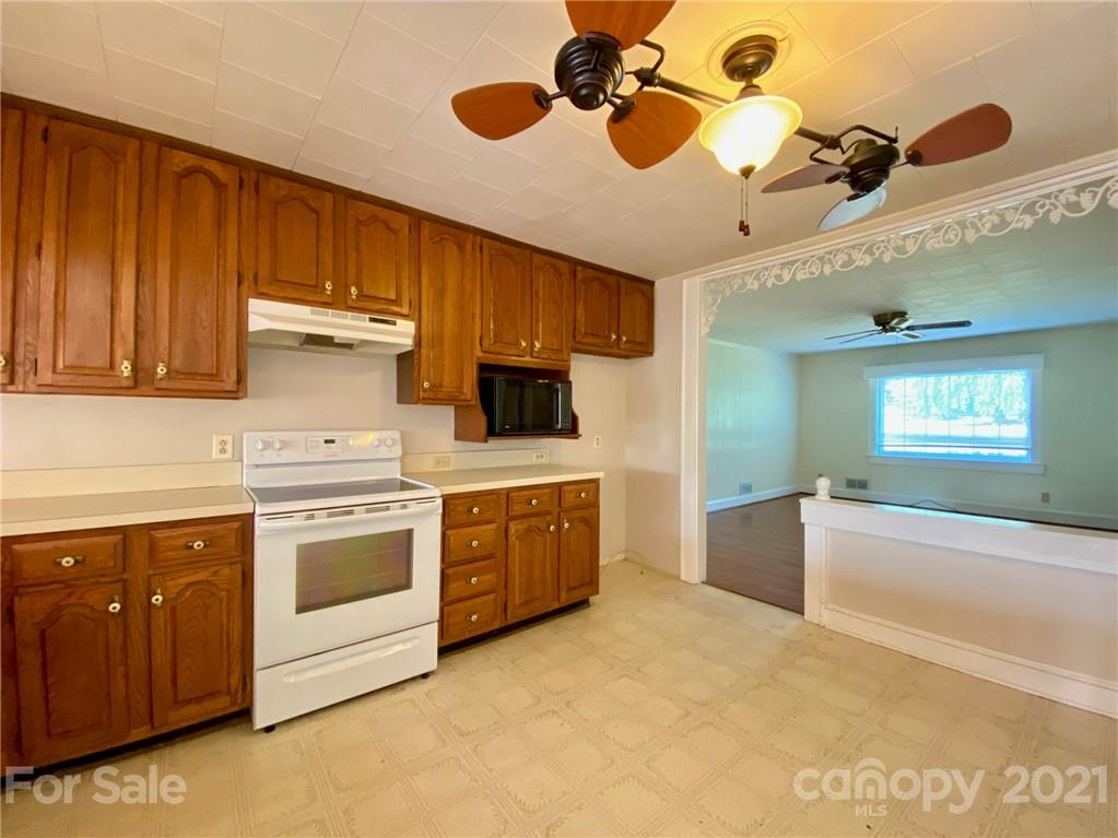 8930 Cool Springs Road Woodleaf, NC 27054 - Photo 24 of 42 a kitchen with a stove sink and cabinets