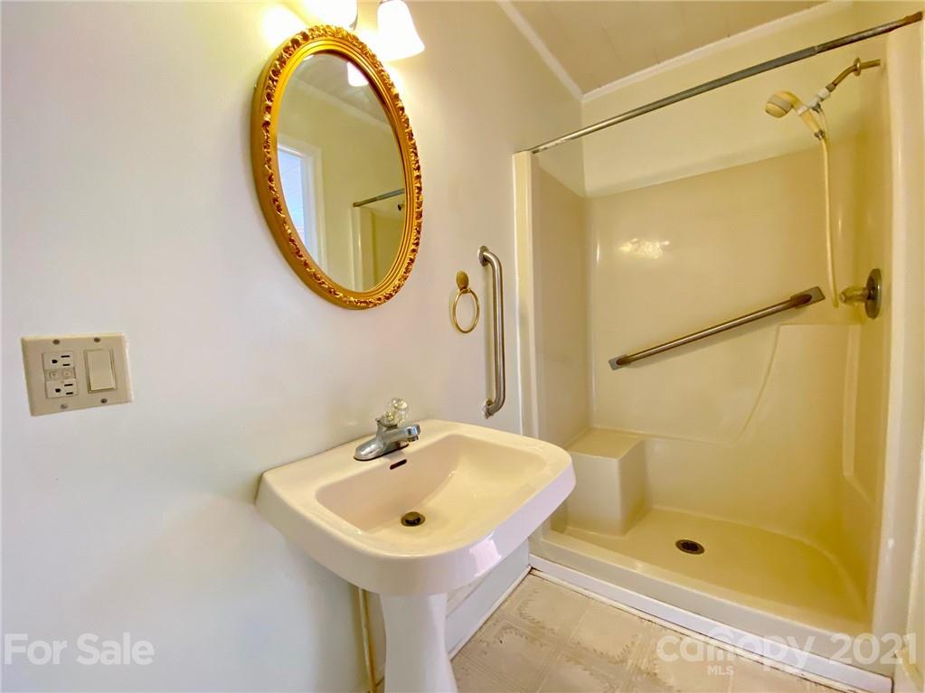 8930 Cool Springs Road Woodleaf, NC 27054 - Photo 28 of 42 a bathroom with a sink a glass door and a mirror