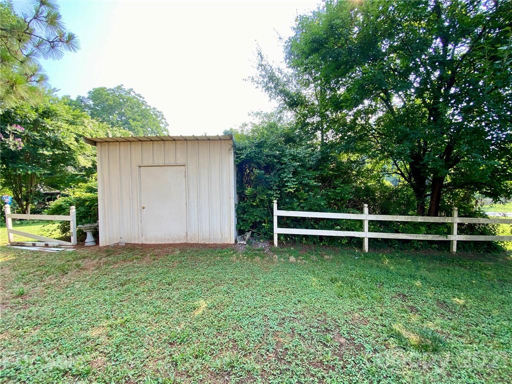 8930 Cool Springs Road Woodleaf, NC 27054 - Photo 34 of 42 a view of a backyard with a bench and a small yard
